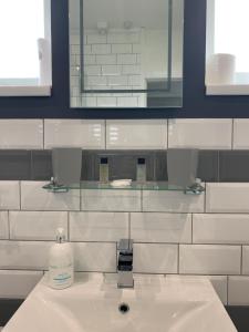 a bathroom with a white sink and a mirror at Bungalow33 Benllech in Benllech