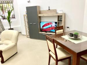 a dining room with a table and a tv at Apartment Tesla in Pančevo
