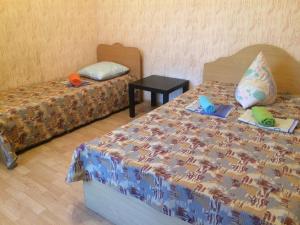 ラザレフスコエにあるAfrodita Guest Houseのベッドルーム1室(ベッド2台、ベッドスカートスペクト付きのテーブル付)