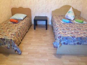ラザレフスコエにあるAfrodita Guest Houseのナイトスタンドとテーブル付きの客室内のベッド2台