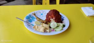 a plate of food on a yellow table at Nas Homestay in Jitra