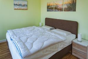 una camera da letto con un grande letto con lenzuola bianche di Waterbed Barth a Barth