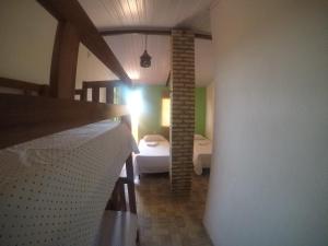 a room with a bedroom with a bed and a light at Hostel Porto Galeão in Baía Formosa