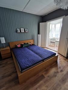 1 dormitorio con 1 cama grande y edredón azul en Gamla skolan rum & övernattning i Spjutstorp, en Spjutstorp