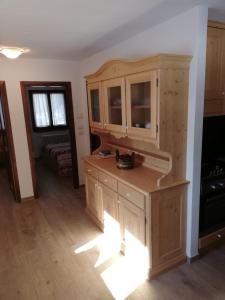 a kitchen with a wooden cabinet in a room at Appartamento panoramico Campitello di Fassa in Campitello di Fassa