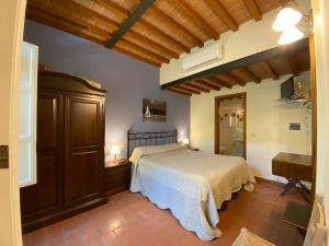 a bedroom with a bed and a desk and a piano at Tenuta Badia '99 in Paciano