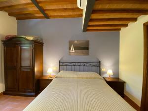 a bedroom with a large bed with two lamps on tables at Tenuta Badia '99 in Paciano