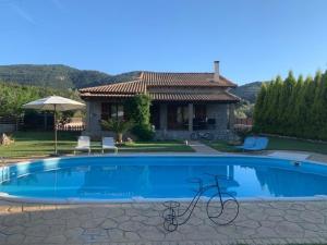 a swimming pool in front of a house at Villa Argie in Nea Epidavros