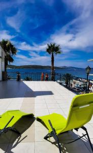 zwei gelbe Stühle auf einer Terrasse in der Nähe des Wassers in der Unterkunft Villa Okruk-10 meters away from the beach in Trogir