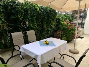 Biały stół z krzesłami i parasolem w obiekcie Villa Rihter w Budvie