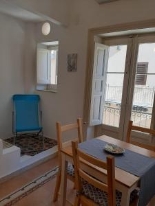 jadalnia ze stołem i niebieskim krzesłem w obiekcie Casa Vacanze Mannina w mieście Castellammare del Golfo
