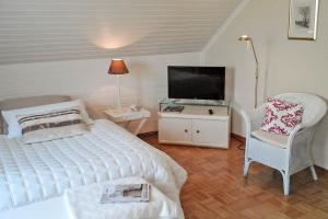 a bedroom with a bed and a tv and a chair at Villa Stephan in Extertal