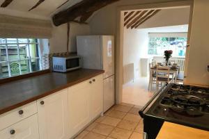 a kitchen with white cabinets and a stove top oven at Stunning Cottage in Picturesque Village in Radlett