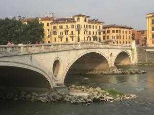 un pont sur une rivière dans une ville avec des bâtiments dans l'établissement Lady Verona Residence, à Vérone