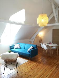 ein Wohnzimmer mit einem blauen Sofa und einem Tisch in der Unterkunft Villa Carlotta - Sea resort in Dieppe