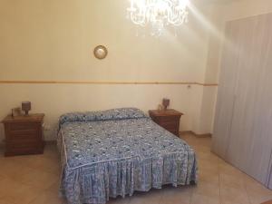 1 dormitorio con cama y lámpara de araña en Barondi Holiday House en Piedimonte Etneo
