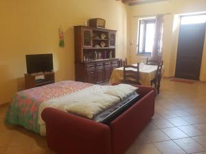 1 dormitorio con cama, mesa y TV en Barondi Holiday House en Piedimonte Etneo