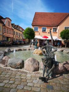 a statue next to a fountain in a city at Ferienhaus HCR Grimmen in Grimmen