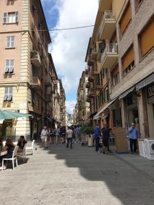 een groep mensen die door een straat met gebouwen lopen bij Beautiful Dream in La Spezia
