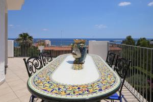 a table with a vase on top of a balcony at villa aurora in Giardini Naxos
