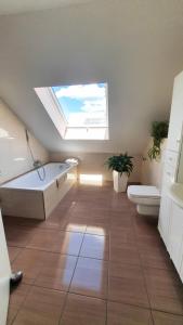 Un baño con bañera, inodoro y ventana. en Ferienwohnung Valerie, en Ettenheim 22 fotos más