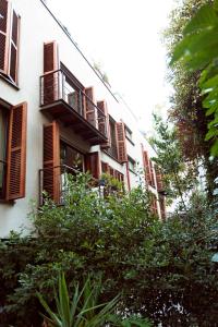 - un bâtiment blanc avec des balcons en bois et des arbres dans l'établissement NOA - Ali Hoca 6, à Istanbul