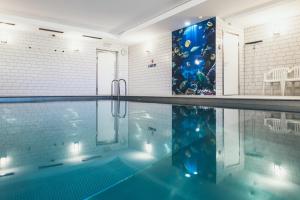 a swimming pool in a room with a tile wall at Karlingerhaus in Königswiesen