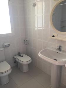 a white bathroom with a toilet and a sink at Bertur Picasso in Peniscola