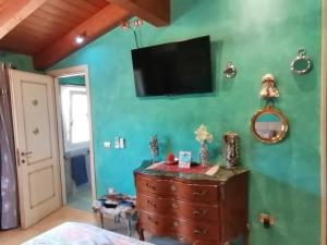 sypialnia z telewizorem na zielonej ścianie w obiekcie Orange Ville w mieście Villamassargia