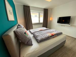 a bedroom with a bed with a television on the wall at Apartment im Zentrum in Kassel