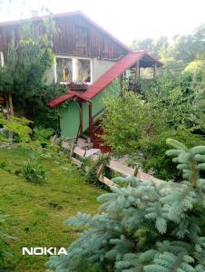 a house with a red roof in a garden at Apartament z ogrodem in Szczytna