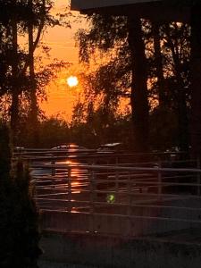 a sunset over a fence with the sun in the background at LUX Apartment KARINA in Dziwnówek