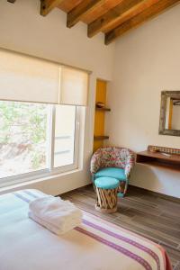 Habitación con cama, silla y ventana en La Cañada en Guanajuato