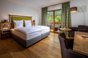 a bedroom with a bed and a living room at Wörndlhof - Das Refugium in Ramsau