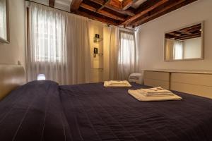 um quarto com uma cama com duas toalhas em Veneziacentopercento Gorne Apartment em Veneza