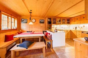 een keuken met houten kasten, een tafel en een wastafel bij Landsitz Rocky Docky in Niedersonthofen