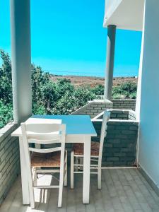 a table and two chairs on a porch with the ocean at Elafonisi Rooms For Rent in Elafonisi