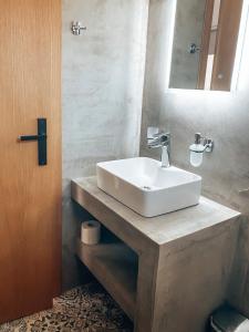 uma casa de banho com um lavatório branco e um espelho. em Elafonisi Rooms For Rent em Elafonisi