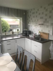 2 rum och kök på Färjestad في كارلشتاد: مطبخ مع مغسلة وطاولة وكراسي
