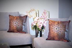 a vase of flowers sitting next to two chairs at Montecito Apartments in Accra