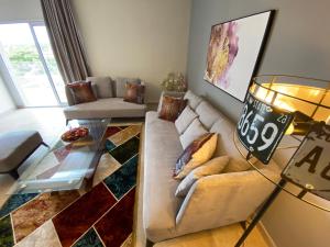 sala de estar con sofá y mesa de cristal en Montecito Apartments, en Accra