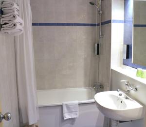 un bagno con vasca, lavandino e doccia di Travelodge Barcelona del Vallés a Barbera del Valles