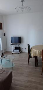 ein Wohnzimmer mit einem Tisch und einem TV in der Unterkunft Pour visiter ou travailler dans le LOIRET in Saint-Jean-de-Braye