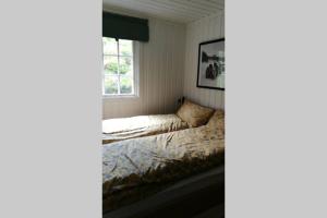 a bed in a room with a window at Nordfjordcabins RED in Utvik