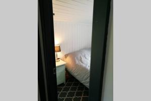 een slaapkamer met een bed en een tafel met een lamp bij Nordfjordcabins Utvik in Utvik