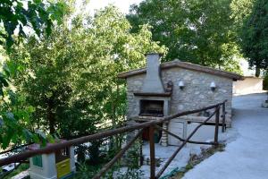 uma pequena casa de pedra com um forno exterior em la casetta delle more (monolocale) em Spoleto