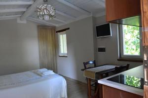 um quarto com uma cama, uma mesa e uma cozinha em la casetta delle more (monolocale) em Spoleto