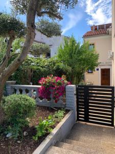 a fence in front of a house with flowers at Taverna coctel in Poreč +15 photos