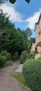 einen Gang in einem Garten mit Büschen und einem Gebäude in der Unterkunft Hotel Carolinenhof in Bad Pyrmont