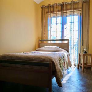 um quarto com uma cama e uma grande janela em Casa dos Gémeos em Sabugueiro